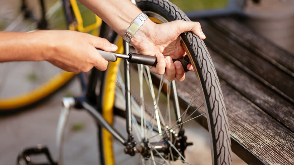 person pumping up bike tire